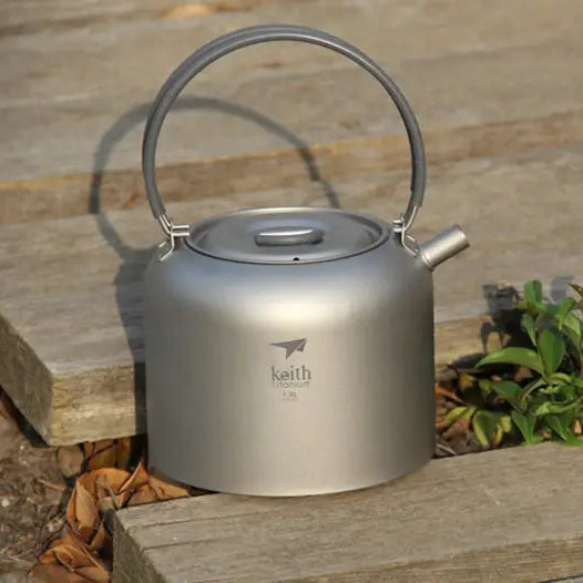 camping kettle with handle on a wooden surface