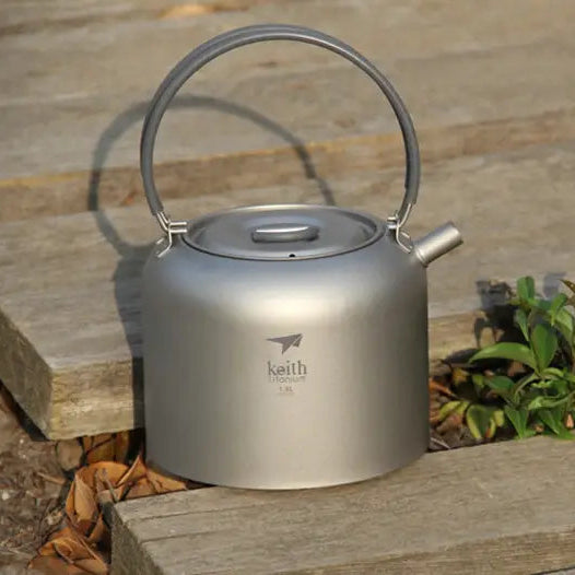 camping kettle with handle on a wooden surface