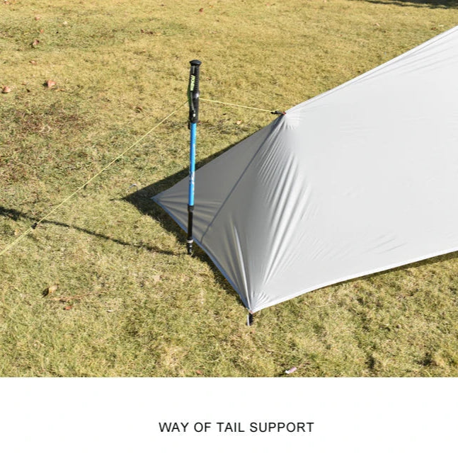 Camping tent with a pole on grass, labeled 'Way of Tail Support'.