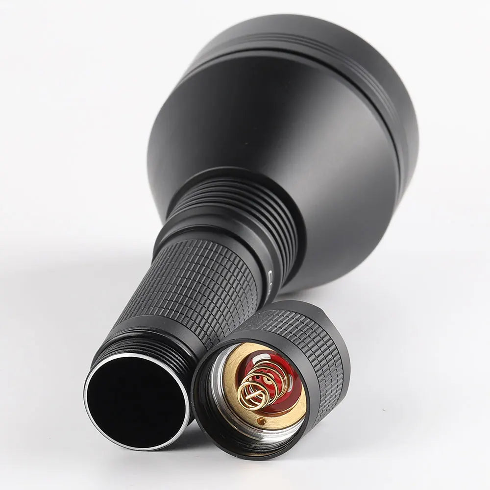 Black flashlight with a detailed focus on the lens and switch on a white background