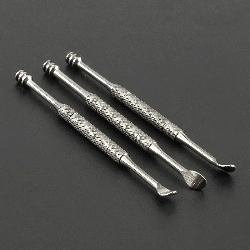 Three metallic tools with textured handles on a dark background