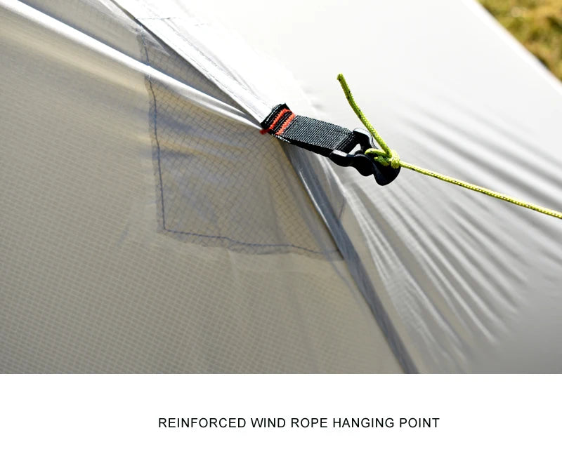 Close-up of a tent with a reinforced wind rope hanging point, showing a strap and rope.