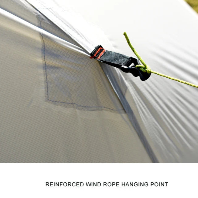 Close-up of a tent with a reinforced wind rope hanging point, showing a strap and rope.