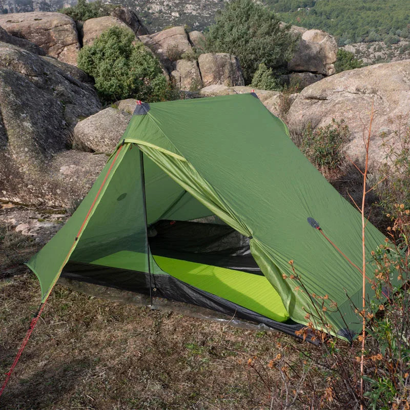 Green Lanshan camping tent set up on a rocky outdoor landscape