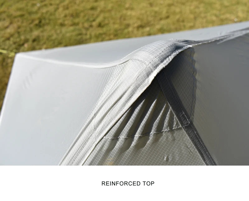 Close-up of a tent with a reinforced top section, grassy background.