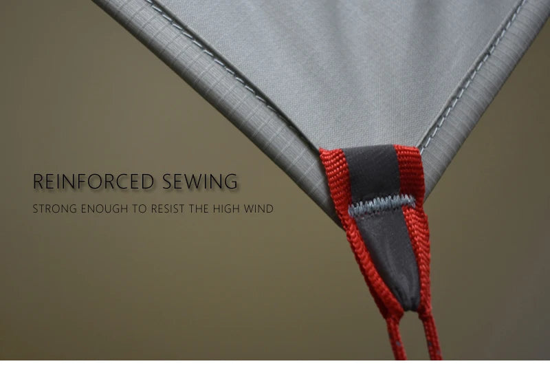 Close-up of a tent with reinforced sewing and red binding on a beige background.