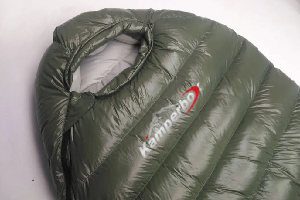 Green sleeping bag with Kamperbox logo on a white background
