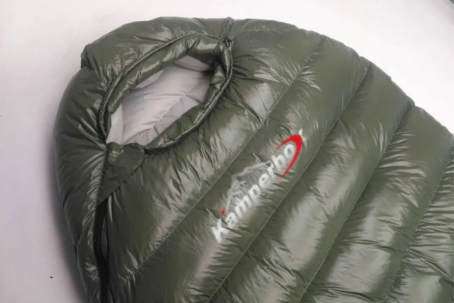 Green sleeping bag with Kamperbox logo on a white background