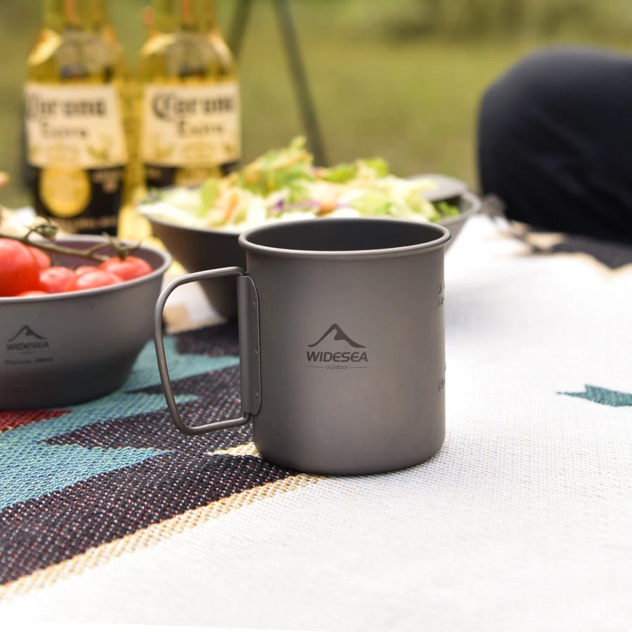 Gray mug with 'Widesea' logo on a picnic setup with food and beer bottles.