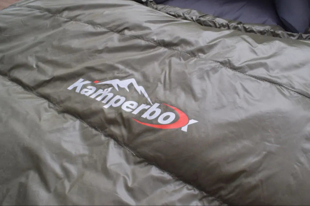 Green sleeping bag with Kampa logo on a plain background