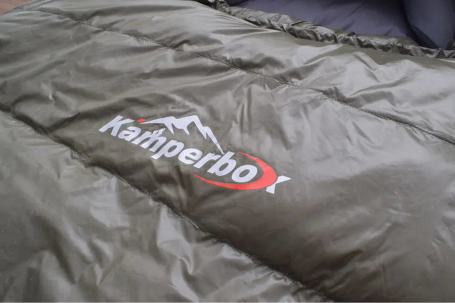 Green sleeping bag with Kampa logo on a plain background