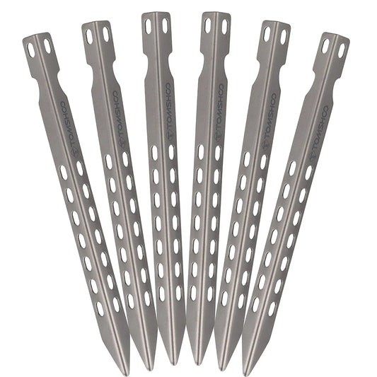 Set of six titanium tent stakes on a white background