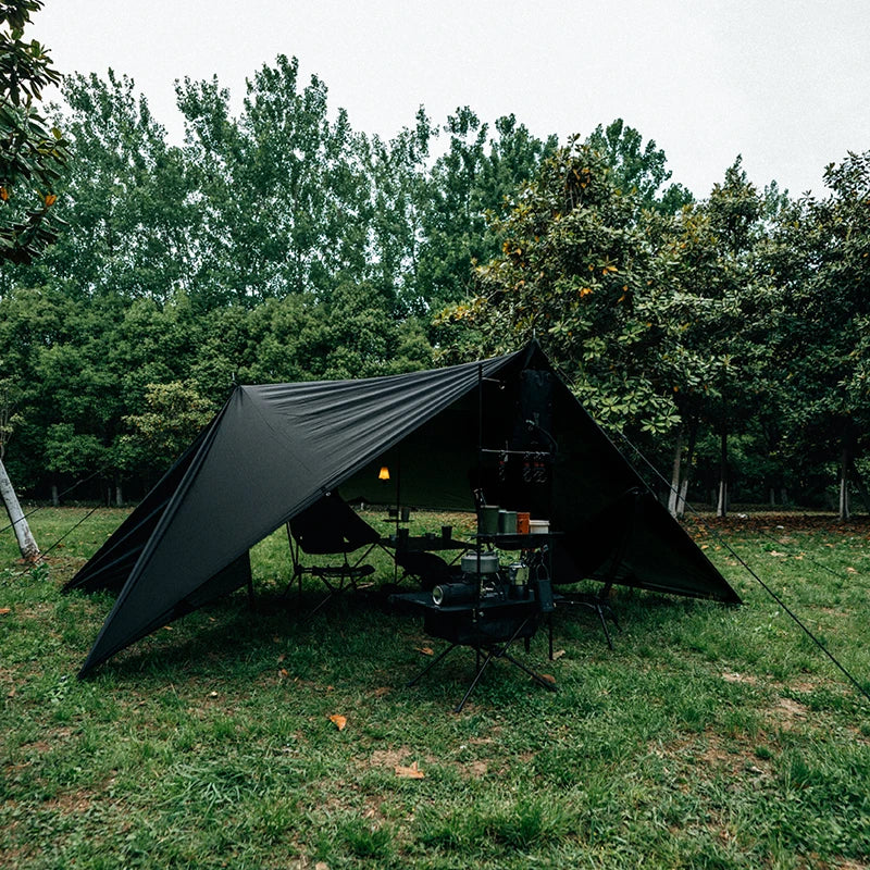 Camping setup with a tarp shelter in a forested area