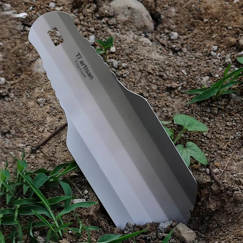 Metal spade tool on a dirt and grass background