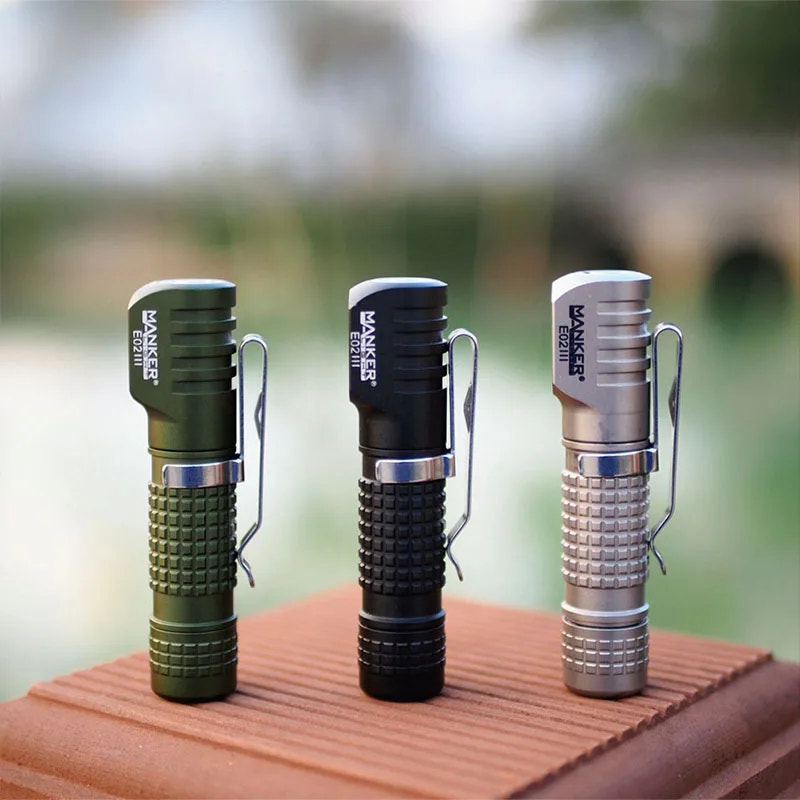 Three flashlights of different colors on a wooden surface with a blurred natural background