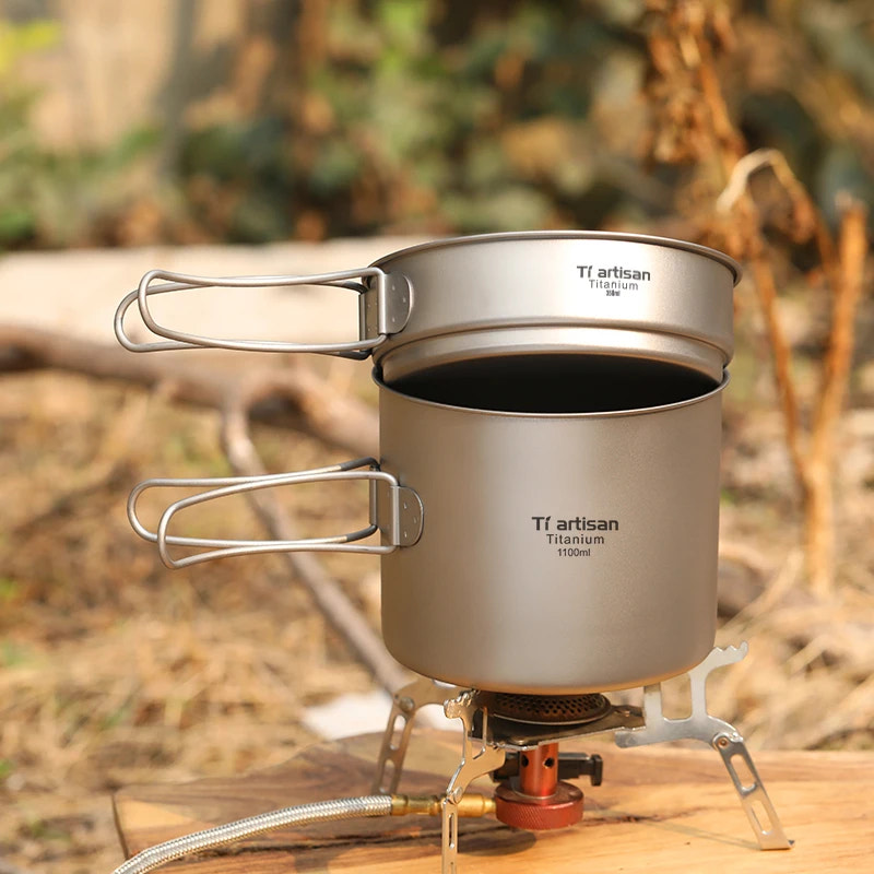 Titanium cookware set on a stove with a natural background