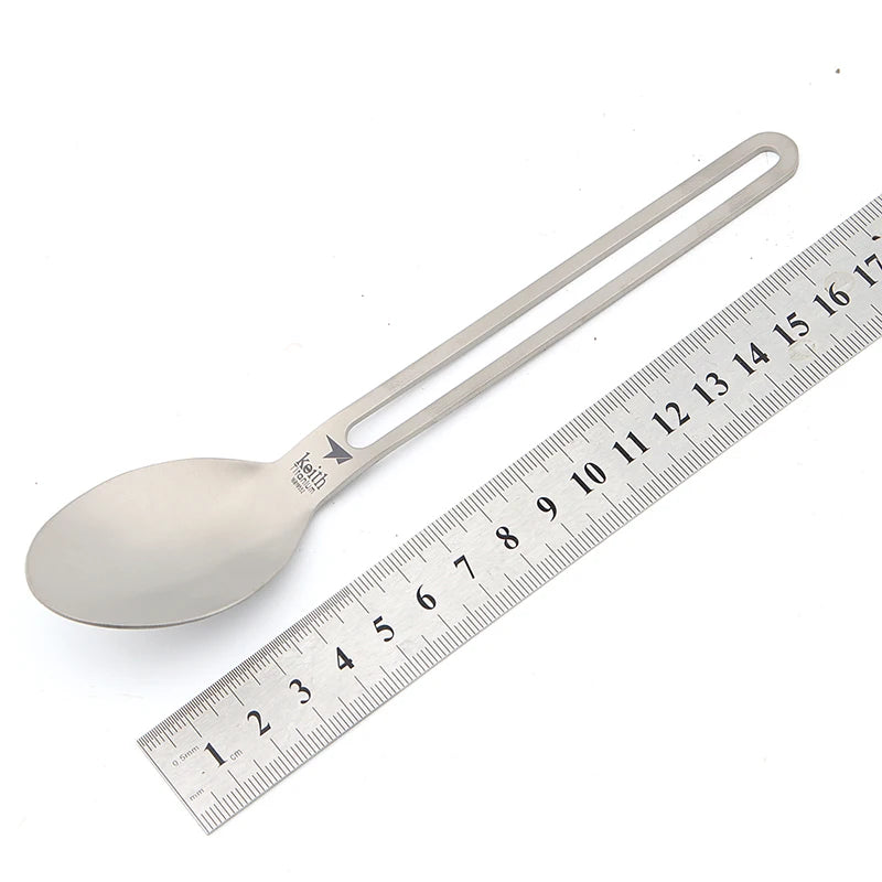 titanium spoon next to a ruler on a white background
