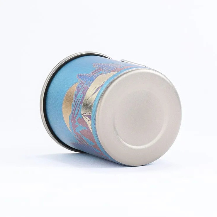 titanium mug with decorative lid on a white background