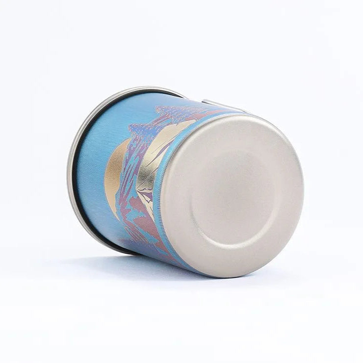 titanium mug with decorative lid on a white background