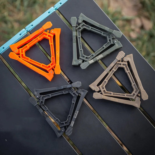 Four gas can stand holders in different colors on a black surface with a natural background.