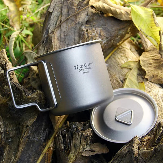 Titanium camping mug with lid on a wooden surface