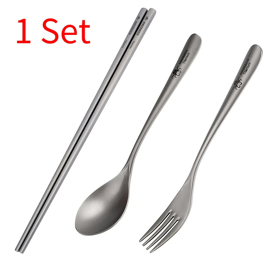 Set of titanium utensils including chopsticks, spoon, and fork on a white background.