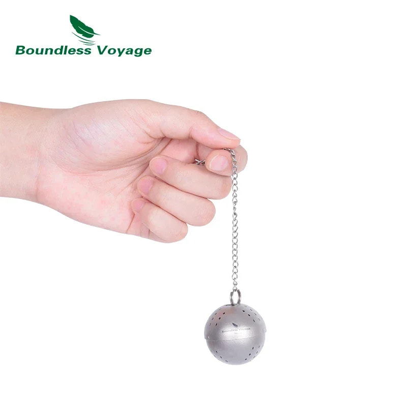 Hand holding a metal tea ball with a chain against a white background, featuring the Boundless Voyage brand.