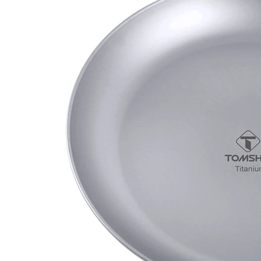 Close-up of a titanium plate with TOMSHOO logo on a white background
