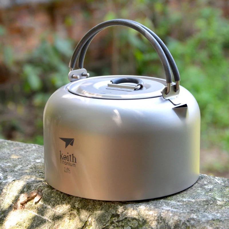 titanium kettle with handle on a stone surface outdoors