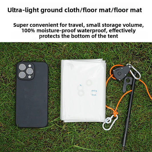 Ultra-light ground cloth/floor mat on grass with phone and tent stakes for scale