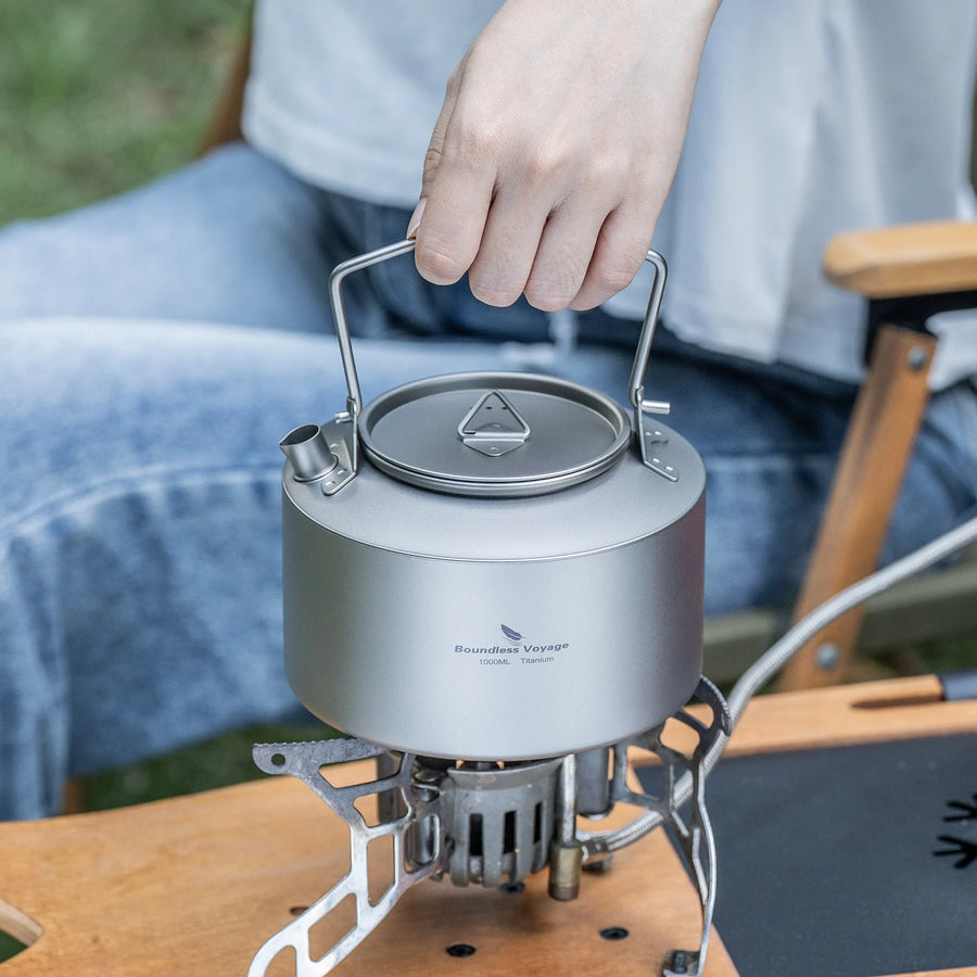 Portable camping stove with a pot on a wooden surface outdoors