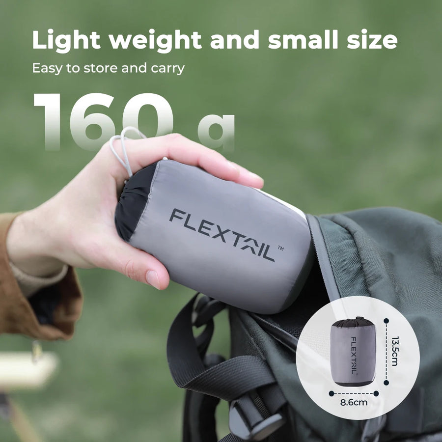 Person holding a gray 'FLEXTAIL' product with text about weight and size on a green background