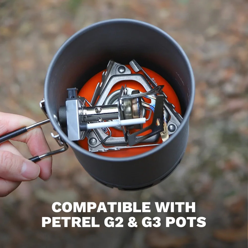 Hand holding a camping stove with compatible Petrel G2 & G3 pots, outdoors.