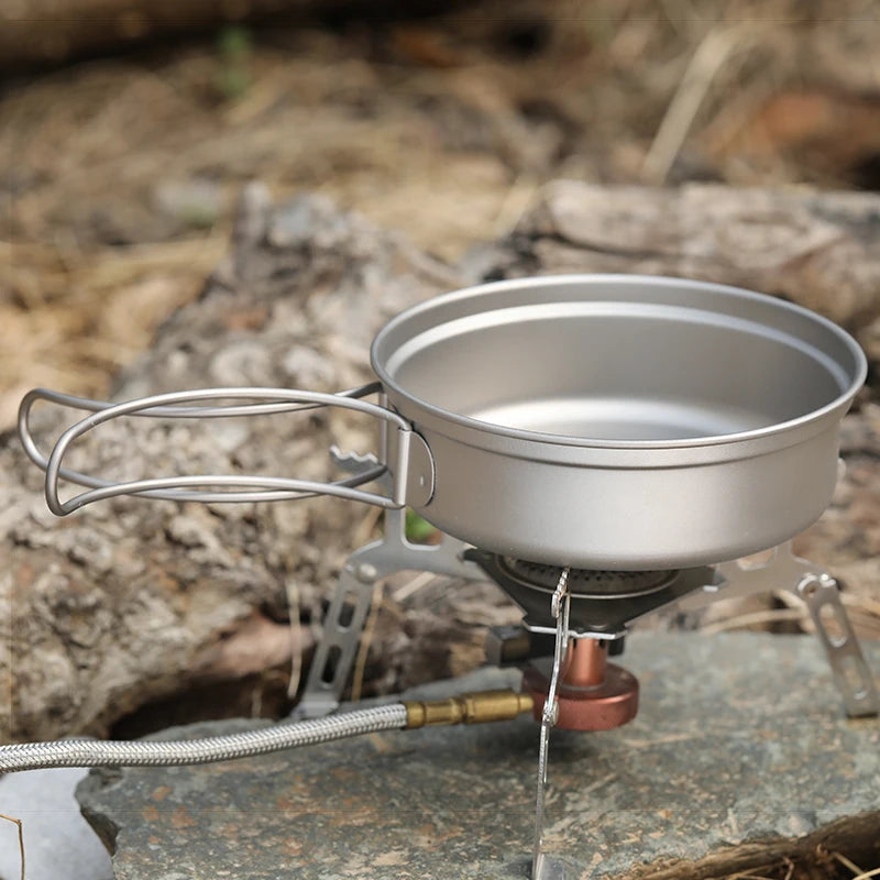 Portable camping stove with a pot on a natural outdoor background