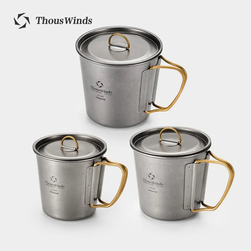 Three metallic mugs with gold handles and lids on a white background, branded 'ThousWinds'.