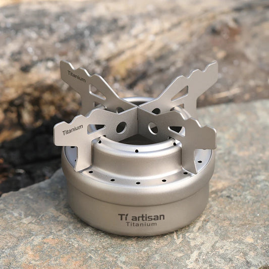 Titanium camping stove on a rock with 'Tiartisan' branding