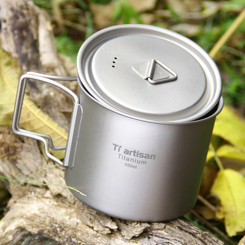 Titanium camping mug with lid on a natural background