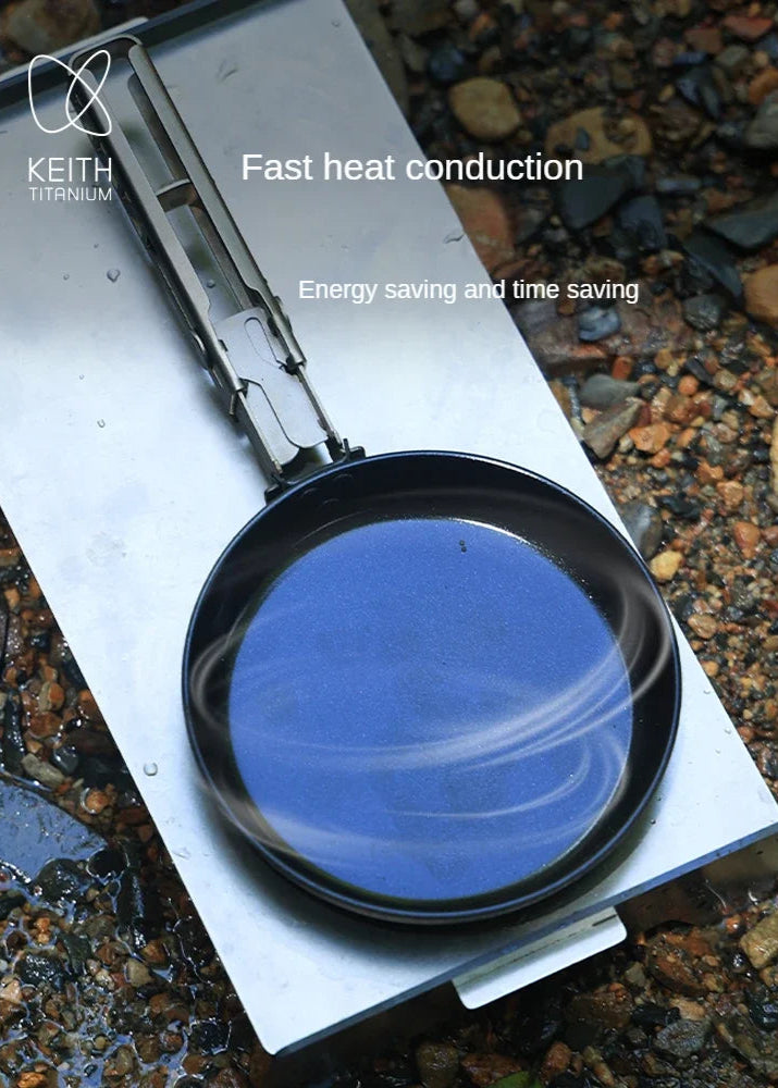 frying pan with blue reflective surface on a metallic base, set against a natural stone background.