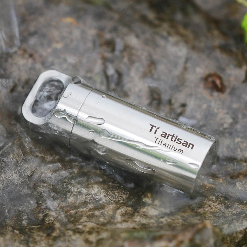 titanium container with 'Ti artisan Titanium' text on a stone surface