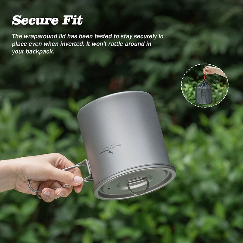 Gray camping mug held by a hand with green foliage in the background