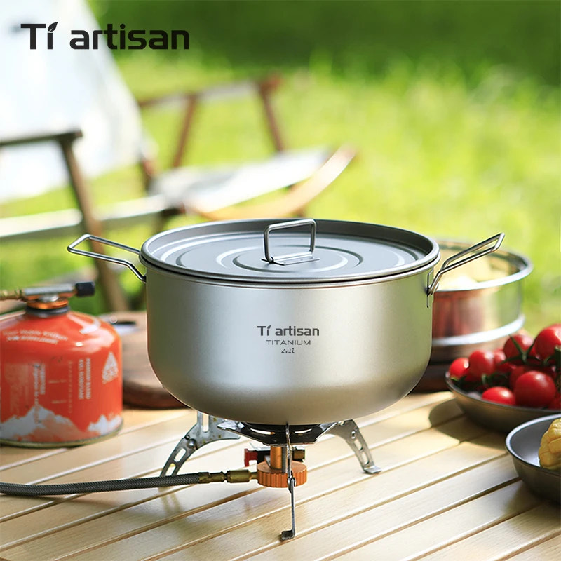 Tiartisan titanium pot on a camping stove with a blurred outdoor background