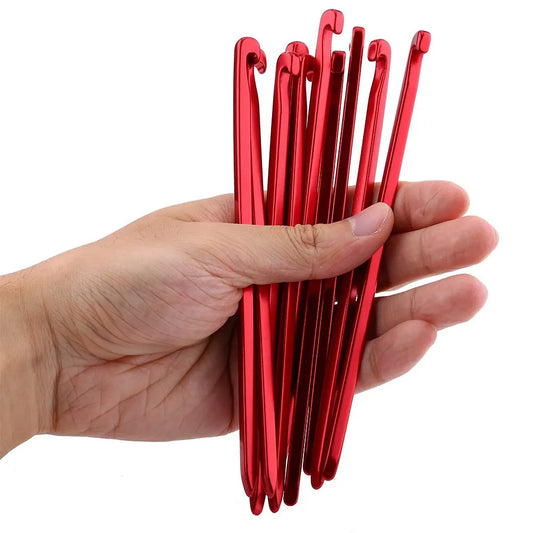 hand holding red tent stakes
