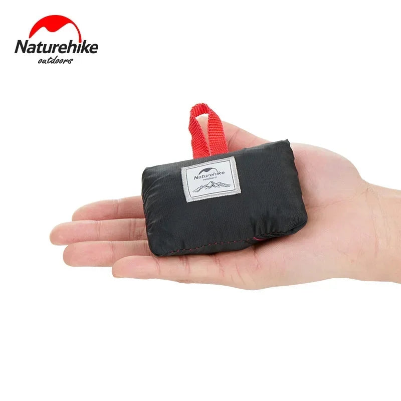 Black pouch with red handle held in a hand, branded with Naturehike on a white background
