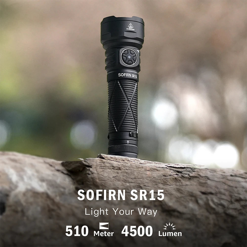 Black flashlight on a log with a blurred natural background