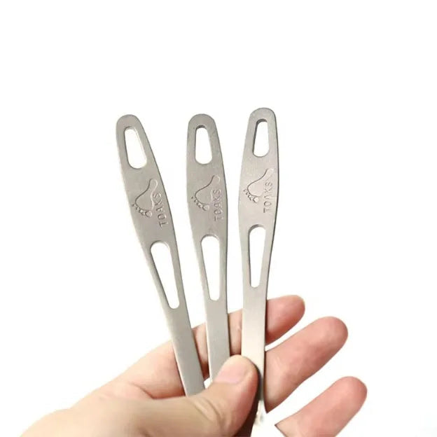 Three metal tools held by a hand with 'TOAKS' branding above.