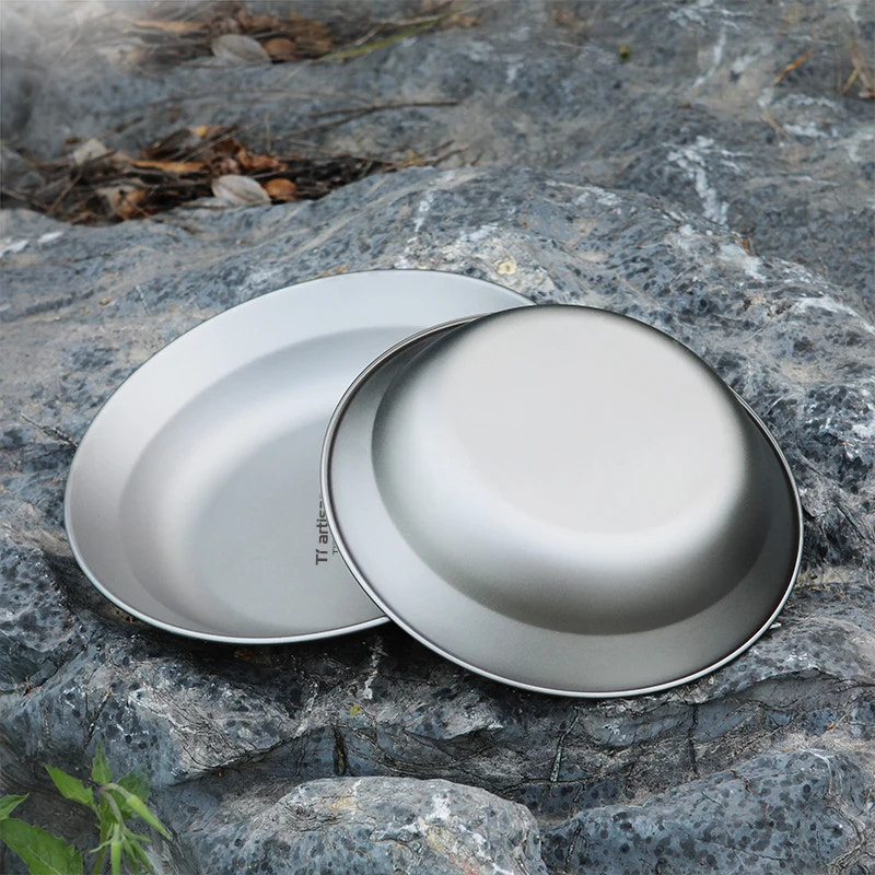 Two metallic bowls on a rocky surface