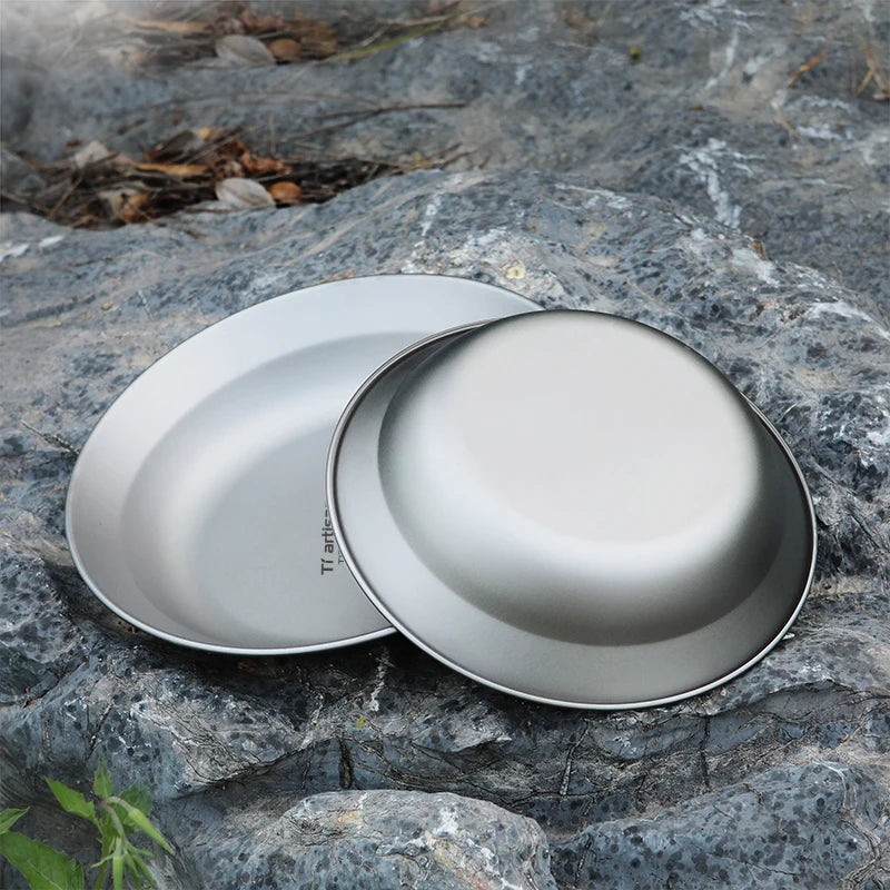 Two metallic bowls on a rocky surface