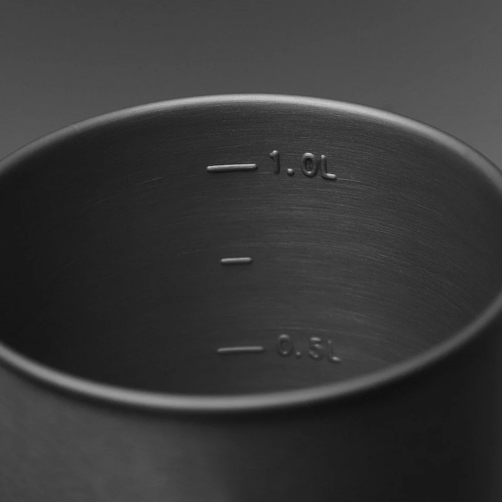 Metal container with measurement markings on a dark background