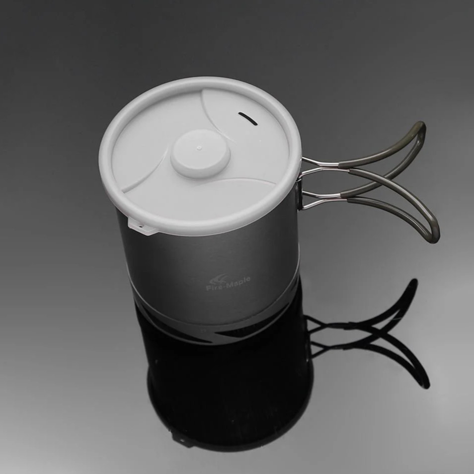 gray metal pot with white lid on a dark background