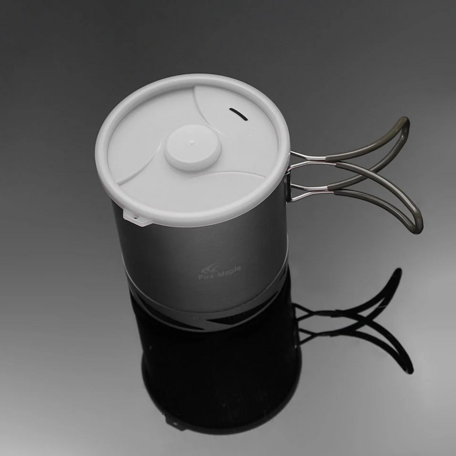 gray metal pot with white lid on a dark background